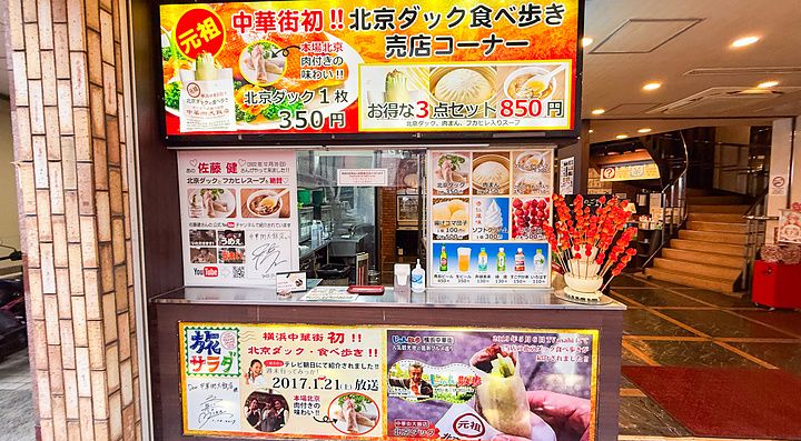 Esterno di Chukagai Daihanten con vetrina e cartellonistica per il cibo d'asporto nella Chinatown di Yokohama.