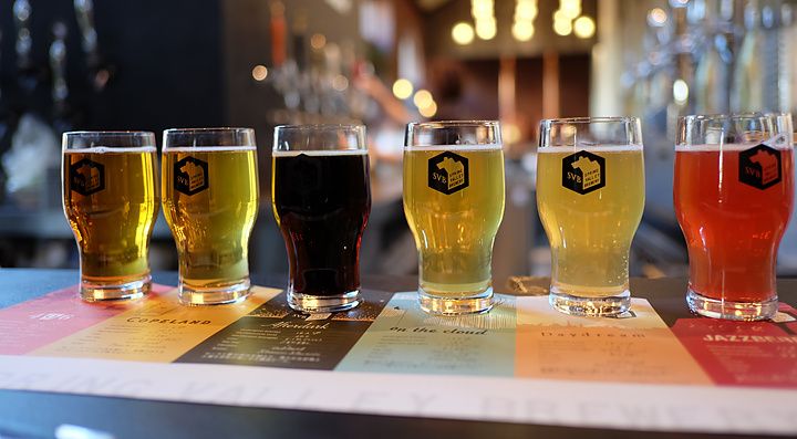 Degustazione di sei diverse birre artigianali allineate su un menu in un birrificio a Yokohama.