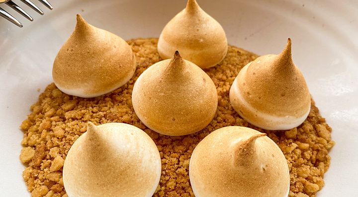 Dolce con meringhe dorate su base di granella in una ciotola bianca presso il ristorante THE APOLLO a Ginza.