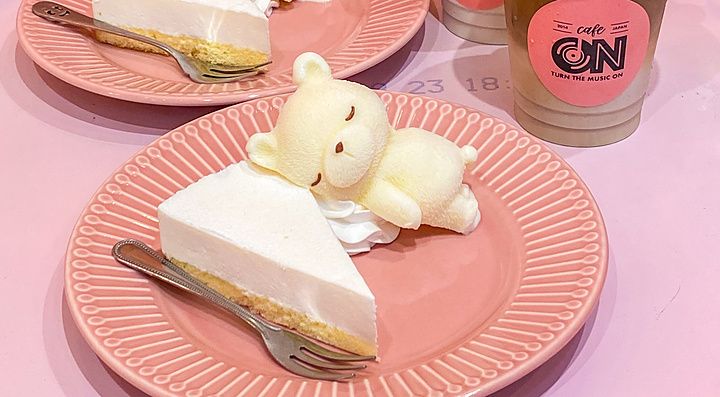 Due piatti con cheesecake e orsetti di panna accanto a caffè ghiacciati con orsetti di ghiaccio al Cafe ON di Tokyo.
