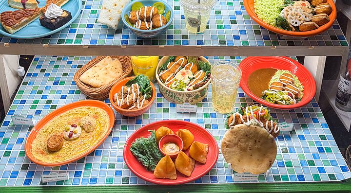 Una vetrina di un ristorante Falafel Brothers in Giappone che espone modelli in plastica di cibi vegani su vari piani.