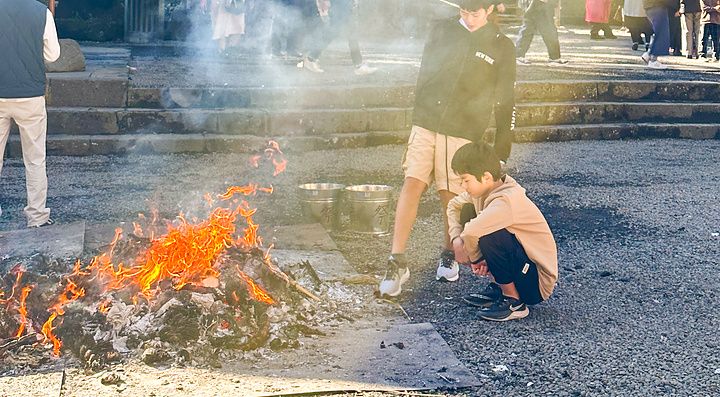 Fuoco cerimoniale durante l'hatsumode al Santuario Kitaguchihongu Fuji Sengenjinja a Fujiyoshida con persone presenti.