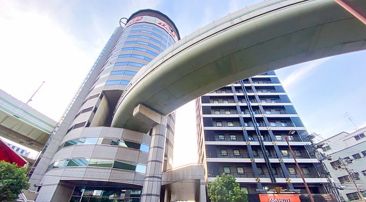 Veduta dal basso del Gate Tower Building a Osaka, con un'autostrada che attraversa la struttura dell'edificio.