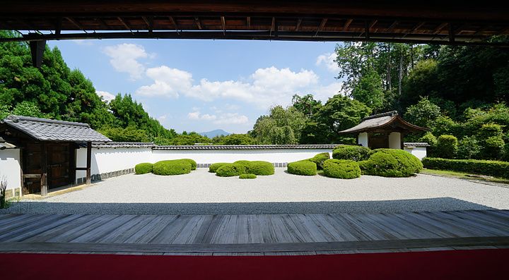 Giardino zen con ghiaia, cespugli potati e vista sul monte Hiei dal tempio Shodenji di Kyoto.