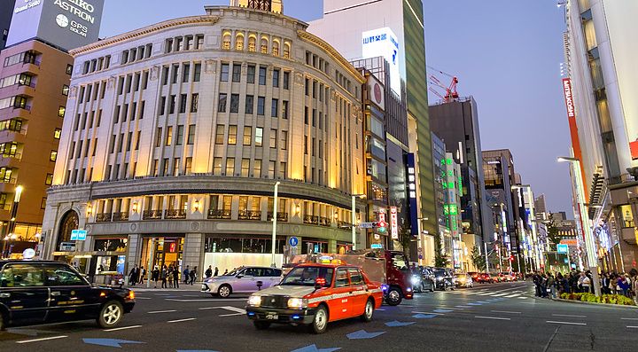 Ginza Wako illuminato di sera con traffico intenso a Ginza, Tokyo.