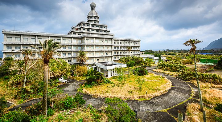 Edificio di un hotel abbandonato circondato dalla vegetazione su Hachijojima.