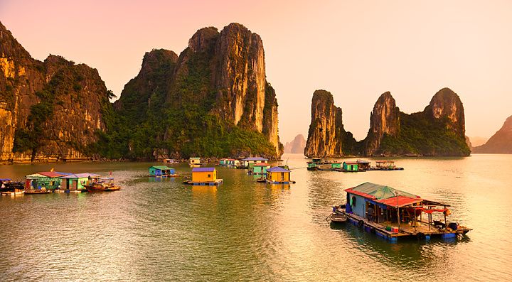 Halong Bay in Vietnam con case galleggianti e formazioni calcaree imponenti.