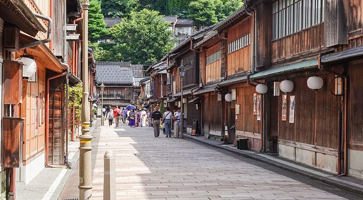 Strada di Higashi Chaya a Kanazawa con edifici in legno e persone che passeggiano.
