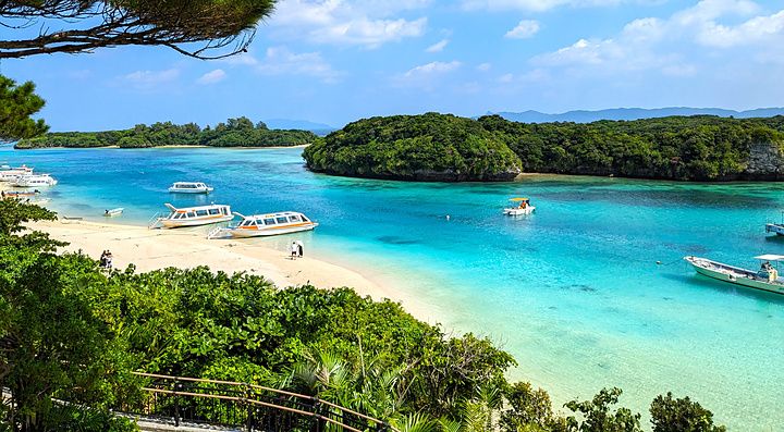 Veduta panoramica di Kabira Bay a Ishigaki con barche sulla riva e mare turchese.