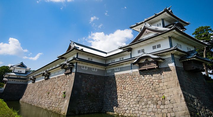 Castello di Kanazawa con mura in pietra e fossato sotto un cielo azzurro.