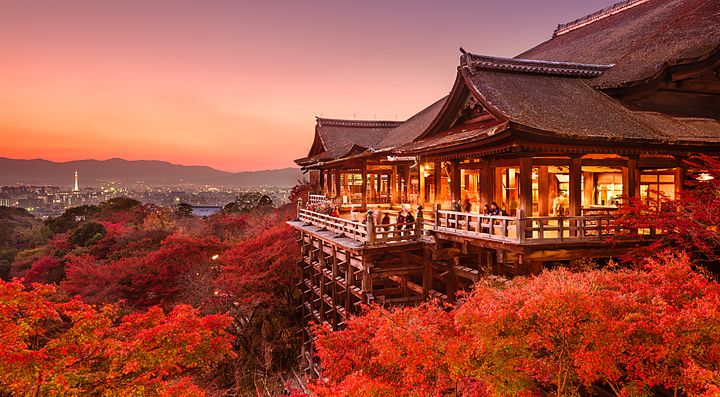 Tempio Kiyomizu-dera di Kyoto al tramonto con foglie autunnali rosse.