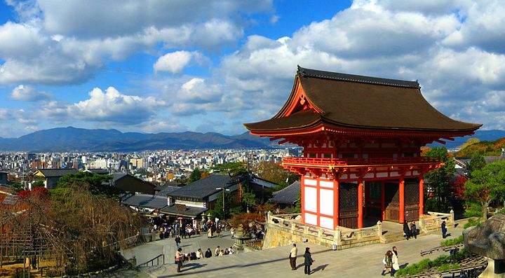 Vista panoramica di Kiyomizu-dera a Kyoto con cielo sereno e vegetazione autunnale.