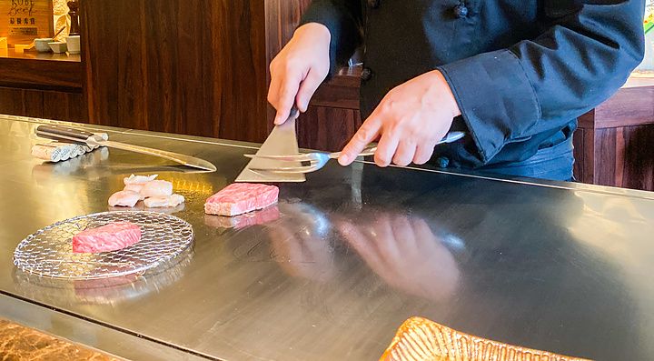 Uno chef prepara carne Wagyu sulla piastra teppanyaki all'interno del ristorante Kobe Beef Ishida a Ginza, Tokyo.