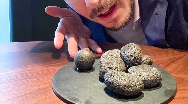 Marco Togni indica un piatto di sassi ricoperti di carbone vegetale, di cui solo uno contiene budin noir, al ristorante La...