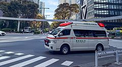 Ambulanza attraversa incrocio tra grattacieli a Shinjuku.