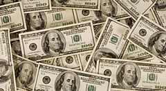 Pila di banconote da 100 dollari americani disposte casualmente.