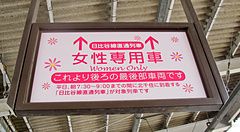 Un cartello rosa rettangolare in Giappone indica la carrozza riservata alle donne presso una stazione.