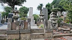 Cimitero giapponese a Yanaka, Tokyo, con lapidi e lanterne in pietra.