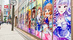Strada di Akihabara con poster anime su parete di vetro.
