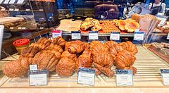 Vetrina colma di vari tipi di croissant e prodotti da forno all'interno di The City Bakery a Shibuya.