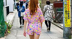 Donna in vestito floreale cammina per una strada stretta a Tokyo.