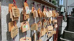 Molte tavolette votive in legno denominate ema sono appese a un supporto presso un tempio in Giappone.