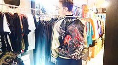 Un uomo indossa una giacca giapponese decorata in un negozio di abbigliamento a Tokyo.