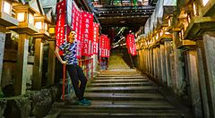 Persona su una scalinata illuminata da lanterne al tempio Gyokuzoin.