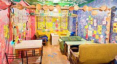 Interno colorato del ristorante OKO a Osaka con pareti piene di scritte lasciate dai clienti e arredi informali.