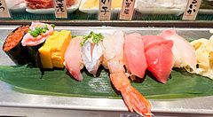 Assortimento di sushi variopinto su una foglia verde in un ristorante.