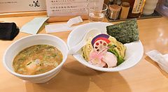 Piatti di ramen con noodles e brodo serviti su un bancone di legno al ristorante Kagari Ramen di Tokyo.