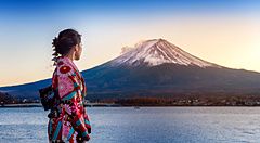 Donna in kimono di fronte al Monte Fuji al tramonto sul lago Kawaguchiko.