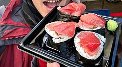 Marco Togni tiene in mano una confezione di maki con tonno acquistata presso la bancarella Maguro Koya a Tsukiji.