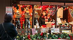 Mercatino natalizio a Roppongi Hills, Tokyo con bancarella decorata e persone.