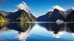 Panorama di Milford Sound con una nave da crociera su acque calme.