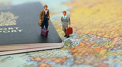 Mini persone su un passaporto canadese su una mappa del mondo.