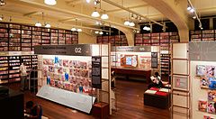 Interno del Museo di Manga a Kyoto con pareti coperte di libri, pannelli espositivi e persone che leggono.
