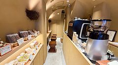 Interno della pasticceria Naki vegan sweets a Namba, Osaka, con scaffali di dolci vegani e un bancone bar.