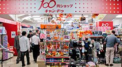 Negozio tutto a 100 yen in Giappone con persone e scaffali pieni di articoli.