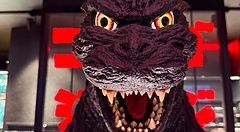 testa di Godzilla in esposizione nel negozio Godzilla illuminata da luci rosse.