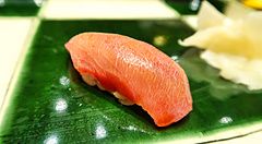 Un nigiri di chutoro servito su un piatto di ceramica verde presso il ristorante Ginza Kyubey di Tokyo.