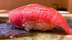 Un nigiri di otoro finemente preparato e servito su un piatto di ceramica presso il ristorante Ginza Iwa a Tokyo.