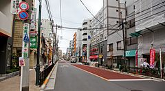 Una strada nel quartiere di Nippori Fabric Town, a Tokyo, fiancheggiata da negozi di tessuti e cavi elettrici aerei.