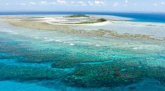 Isola tropicale deserta con acque blu limpide e reef corallino, Okinawa.