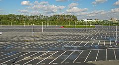 Parcheggio vuoto a Tokyo Disneyland con un'auto rossa.