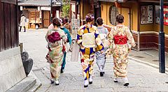 persone in kimono camminano in una strada tradizionale a Kyoto.