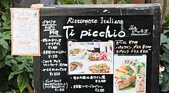 Cartello di un ristorante italiano in Giappone con menu in italiano e giapponese.