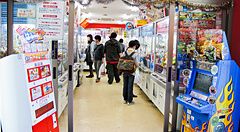 Sala giochi in Giappone con persone che giocano alle macchine a premi.