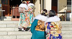 Persone in kimono tradizionale davanti all'ingresso principale del Santuario Namba Yasaka a Osaka.