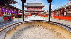 Persona davanti al tempio Senso-ji ad Asakusa, Tokyo, con grande braciere in primo piano.